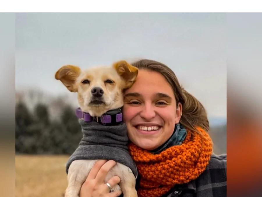 Jess Gorham smiling with a small dog perched on her shoulder